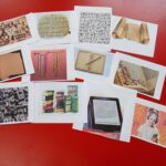Leżące na stole ilustrację przedstawiające historię powstawania książki - od pisma obrazkowego do obecnie stosowanych e-book'ów