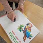 Opieczętowanie książki okrągłą pieczątką biblioteczną.