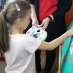 Dzieci wykonują pamiątkowe plansze, na których oprócz zdjęć grupowych przyklejają czerwone karteczki ze swoimi imionami
