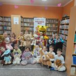 Dzień Pluszowego Misia w bibliotece - zdjęcie grupowe Kubusia Puchatka z uczestnikami spotkania