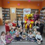 Dzień Pluszowego Misia w bibliotece - zdjęcie grupowe Kubusia Puchatka z uczestnikami spotkania