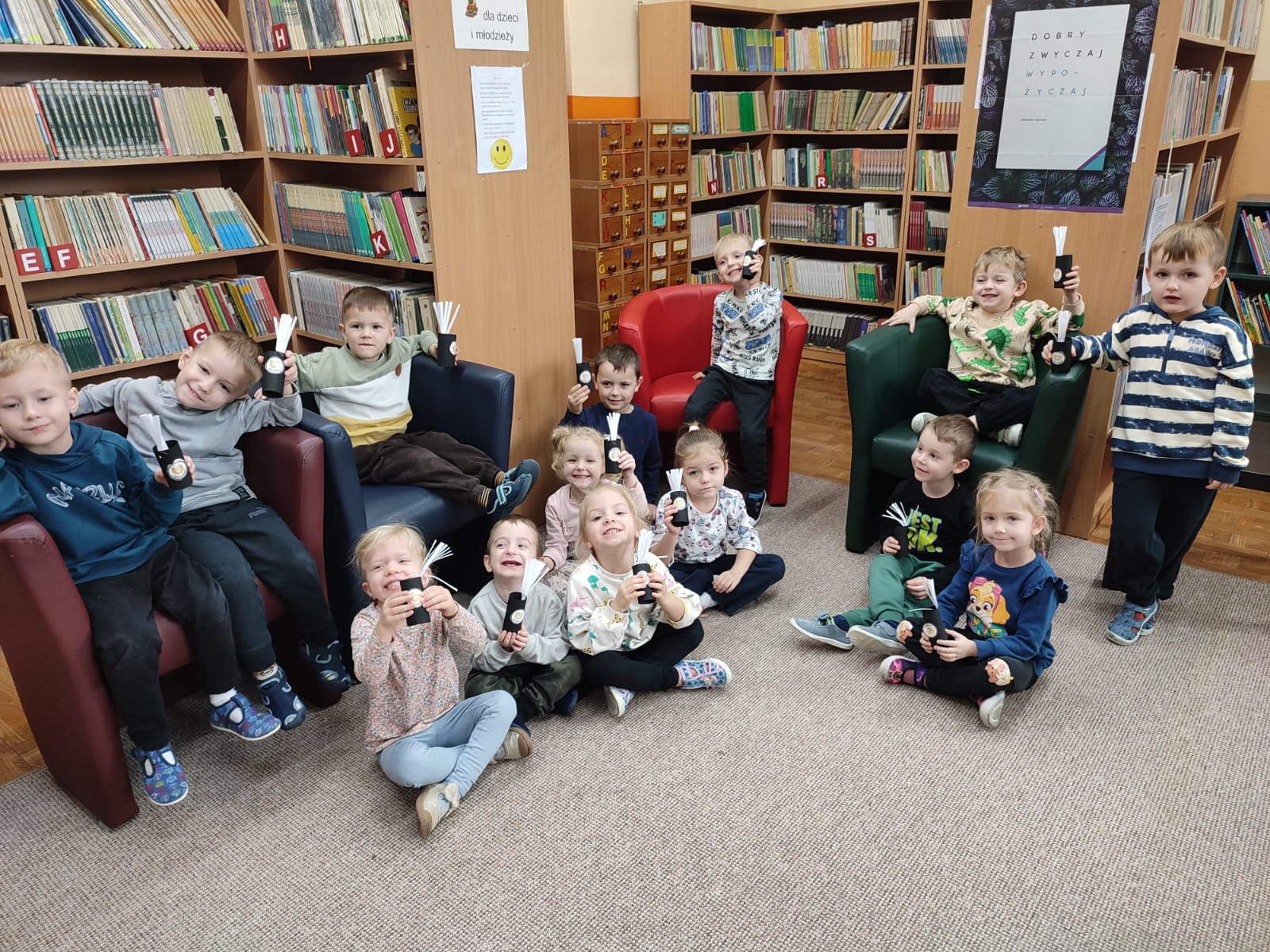 Zdjęcie zbiorowe dzieci - uczestników spotkania - prezentujących wykonane przez siebie prace