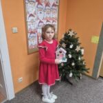 Dziewczynka prezentuje wykonaną pracę plastyczną