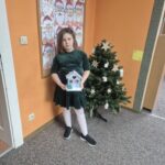 Dziewczynka prezentuje wykonaną pracę plastyczną