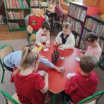 Dzieci przy stolikach wykoują pracę plastyczną