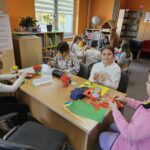 Uczestnicy spotkania wykonują prace plastyczne dla Babć i dziadków