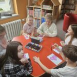 Dzieci przy stoliku wykonują pracę plastyczną