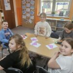 Dzieci przy stoliku wykonują pracę plastyczną