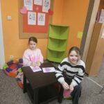 Dzieci przy stoliku wykonują pracę plastyczną