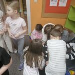 Dzieci przy stoliku wykonują pracę plastyczną