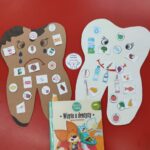 Wykonane prace - papierowe zęby - biały i brązowy, z naklejonymi przez dzieci obrazkami przedstawiającymi dobre i złe produkty dla naszych zębów