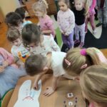 Dzieci przyklejają do papierowych zebów dobre i złe produkty dla naszych ząbków - dobre na biały ząbek a złe na brązowy