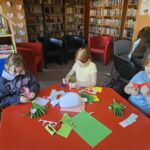 Dzieci przy stoliku wykonują pracę plastyczną