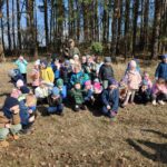 Grupa dzieci na wycieczce do lasu podczas spotkania z Panem Czesławem Tyrolem