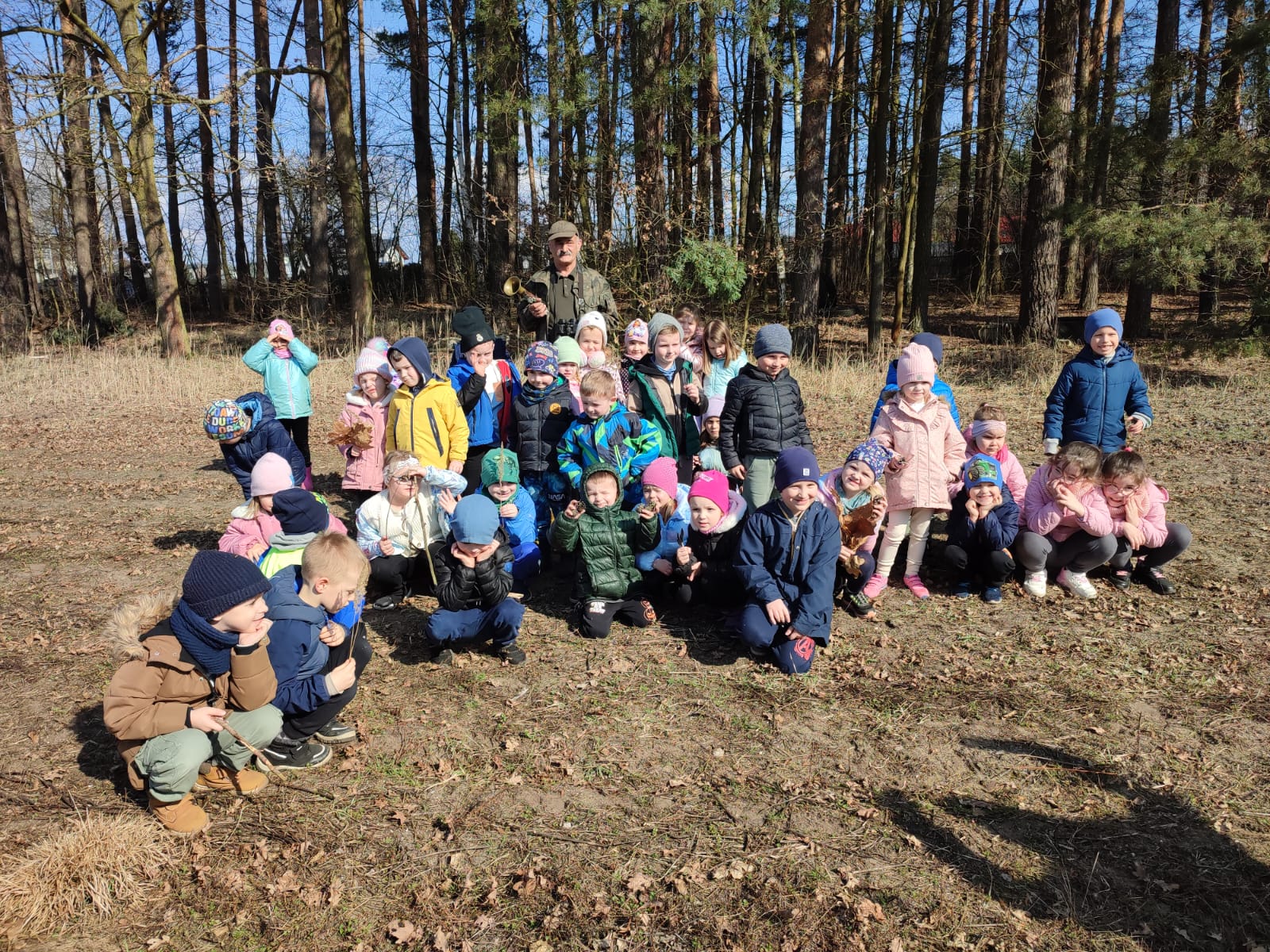 Grupa dzieci na wycieczce do lasu podczas spotkania z Panem Czesławem Tyrolem