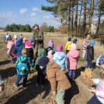 Grupa dzieci na wycieczce do lasu podczas spotkania z Panem Czesławem Tyrolem