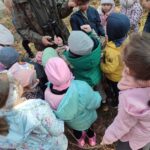 Grupa dzieci na wycieczce do lasu podczas spotkania z Panem Czesławem Tyrolem