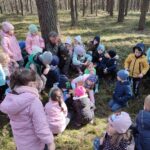Grupa dzieci na wycieczce do lasu podczas spotkania z Panem Czesławem Tyrolem