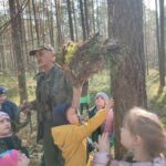 Grupa dzieci na wycieczce do lasu podczas spotkania z Panem Czesławem Tyrolem