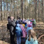 Grupa dzieci na wycieczce do lasu podczas spotkania z Panem Czesławem Tyrolem
