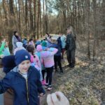 Grupa dzieci na wycieczce do lasu podczas spotkania z Panem Czesławem Tyrolem