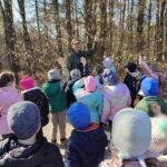 Grupa dzieci na wycieczce do lasu podczas spotkania z Panem Czesławem Tyrolem
