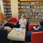 Dzieci przy stoliku wykonują pracę plastyczną