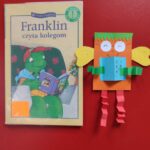 Okładka książki "Franklin czyta kolegom", obok książki leży wykonana praca plastyczna