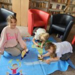 Dzieci na ziemi wykonują pracę plastyczną