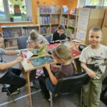 Uczestnicy spotkania wykonują prace plastyczne